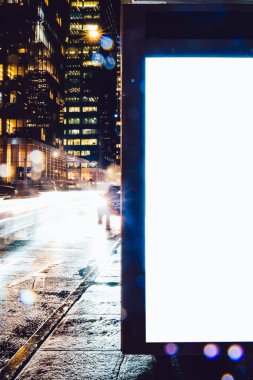 Reklam veya promosyon içeriği için boş kopya boşluk ekranı ile yağmurlu gece otobüs terminali Billboard, bilgi için lightbox kadar boş sahte, uzun pozlama ile kentsel şehir sokakta boş ekran