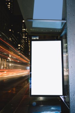 Reklam veya promosyon içeriği için boş kopya boşluk ekranı ile yağmurlu gece otobüs terminali Billboard, bilgi için lightbox kadar boş sahte, uzun pozlama ile kentsel şehir sokakta boş ekran