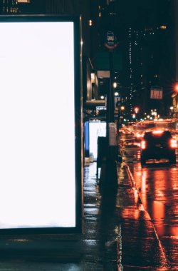 Reklam veya promosyon içeriği için boş kopya boşluk ekranı ile yağmurlu gece otobüs terminali Billboard, ışık ile kentsel şehir sokakta boş ekran bilgi için lightbox kadar boş mock