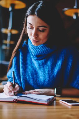 Çekici genç yetenekli kadın yazar yeni kitap makaleleri kafeteryaya istirahat ederken notları, düşünceli Blogger kız rahat kapalı boş yerde ders kitabında yazma fikirleri oluşturma giyinmiş