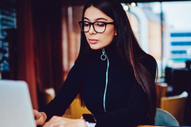 Yetenekli genç kadın yazılım geliştiricisi dizüstü bilgisayar üzerinden göz koruma çalışma sağlamak için gözlükler içinde WiFi Kapalı, trendy akıllı hipster kız bağlı Netbook yeni antivirüs yükleme