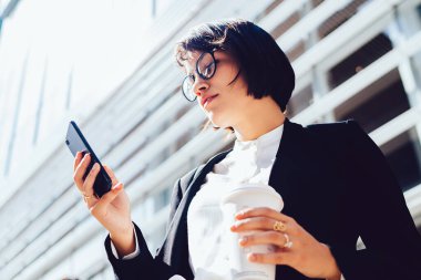 Manhattan 'da finans dünyasıyla ilgili haberleri okumak için kahvenin altında iş molası sırasında şehrin sokaklarında duran çekici bir kadın hücresel bağlantıda 4G kullanıyor.