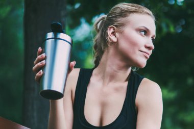 Büyüleyici iyi görünümlü kadın Runner şehir etrafında sabah jogging sonra kentsel ayarı üzerinde tezgah istirahat, cazip sporcu düşünceli uzak doğada sert egzersiz başlamadan önce bakıyor