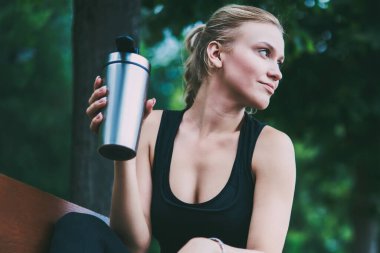 Büyüleyici iyi görünümlü kadın Runner şehir etrafında sabah jogging sonra kentsel ayarı üzerinde tezgah istirahat, cazip sporcu düşünceli uzak doğada sert egzersiz başlamadan önce bakıyor