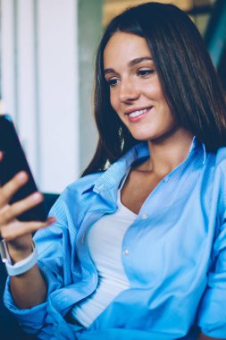 Olumlu beyaz kadın Blogger kendi popüler web sayfasından takipçileri ile online sohbet zevk, mutlu hipster kız akıllı telefon Gadget tutarak ve iletişim için yeni bir uygulama indirme