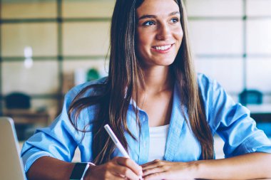 Modern laptop cihazı kapalı, okul projesi için fikirler hakkında düşünme genç olumlu kadın öğrenci ile masaüstünde otururken netbook zevk planlama süreci ile başarılı kadın gülümseyen