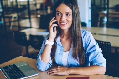 Mutlu kadın öğrenci akıllı telefon Gadget üzerinde uygulama ile dostu konuşma zevk, başarılı hipster kız okumak ve e laptop öğrenme break sırasında iletişim için cep telefonu kullanarak