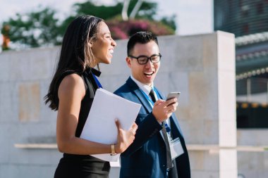 Zarif giysiler ve kimlik kartlarıyla sokaklarda gezen neşeli modern kadın ve erkeğin yan görüntüsü.