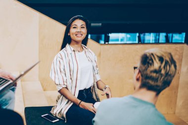Çok ırklı öğrencilerden oluşan güler yüzlü bir grup ev ödevi projesinde üretken çalışma sürecinden memnun, araştırma için dizüstü bilgisayar kullanıyorlar, yaratıcı milenyum hippileri başlangıçta işbirliği yapıyorlar.
