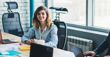 Ofis masasının yanında birlikte çalışan ve yönetim projesinden, girişimcilikten ve takım çalışmasından ayrılırken kameraya bakan mutlu erkek ve kadın finans uzmanlarının portresi