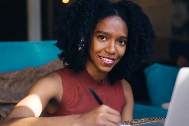 Loft iç otodidakt için zaman içinde kamera gülümseyen karanlık cilt ile mutlu kadın öğrenci portresi, neşeli Afrikalı Amerikalı kadın e öğrenme ve hazırlık ders çalışması için zevk