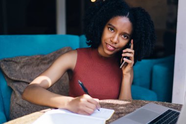 Cep telefonu uygulaması, modern teknoloji kavramı ile ilgili detayları tartışmak sırasında organizasyon planı yazmak için ders kitabı ile masada oturan kafeteryanın çekici kadın yöneticisinin portresi