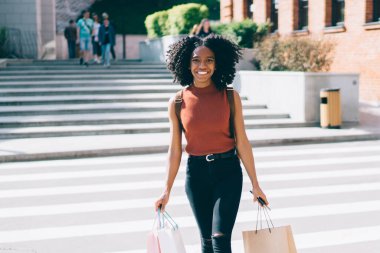 Şehirde boş sırasında kamera gülümseyen el satın alma ile mutlu neşeli kadın hipster tam uzunlukta portre, satış ile alışveriş için gündelik aşınma harcama günü giyinmiş mutlu kadın
