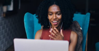 Mutlu koyu tenli hippi kız internet sitesinden gelen motivasyonlu bilgilere şaşırmış durumda. Netbook 'a müzik çalma listesi indirdiği için yüksek hızlı internet bağlantısından şoke olmuş durumda.