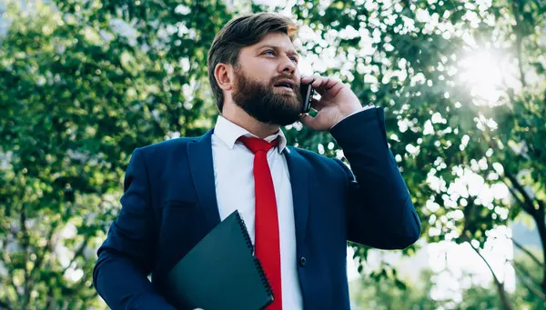 Stresli, takım elbiseli iş adamlarının acil bir sorunu çözmek için telefonda konuştuğu dosyalar ve iş merkezinin yakınındaki bir sokakta taşıdığı belgeler.