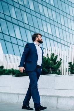 Şık elbiseli, akıllı telefonlu yakışıklı işadamından. Uzaklara bakıyor ve cadde boyunca yürürken şehirdeki bulanık gökdelenlere karşı kafa yoruyor.