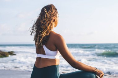 Güzel Hint plajında yoga spor eşofman giymiş çekici Afrikalı Amerikalı bir kız tarafından gerçekleştirildi. Nilüfer çiçekli sakin bir kadın tarafından okyanus kenarında akşam ruhani eğitimi verildi. Meditasyon yapıyordu.