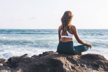 Esmer tenli bir kadının yeniden canlandırma için denge kurması ve kendi zihinlerinde huzur ve çakra bulması, rahatlama uyumu ve Endonezya Bali Denizi yakınlarında ruhsal süreç kavramı.