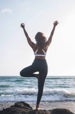 Kadının diğer asanalara sorunsuzca gidebilmek için geçiş ağacı duruşunu arka planda tutması, denge duygusunu geliştirmek ve siyatiği azaltmak için vrikshasana uygulaması ve düz tabanı azaltması.