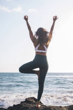 Zihinsel berraklık ve zihin sakinliği yaratmak için düzenli yoga yapan fitness kızının arka görünüşü, arama zen ve çakra için manevi egzersiz sırasında Asana 'ya poz veren genç kadın