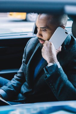 İş ortaklarıyla iş iletişimi için uluslararası gezici internet bağlantısı kavramı, Afrikalı Amerikalı bir adamın araba sürüşü sırasında dijital cihaz uygulaması için operatöre telefon etmesi