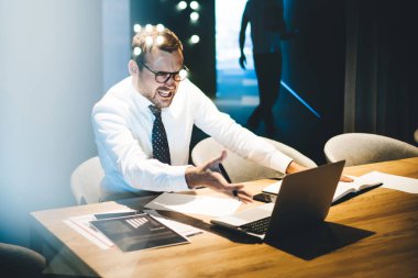 Modern ofiste çalışan stresli iş adamı dizüstü bilgisayara bağırıyor ve mali durum hakkında kızgın oluyor, kızgın erkek muhasebeci müşterilerin sorunlarını çözemiyor.