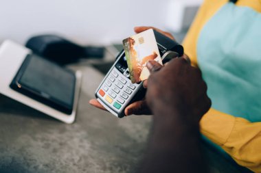 Modern kafede kimliği belirsiz siyahi bir kadına para öderken terminalin yakınında kimliği belirsiz bir Afrikalı Amerikalı erkeğin elinde.