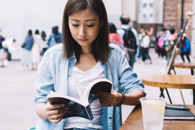 Kot gömlekli zeki bir bayan öğrenci kafeteryada oturan ilginç bir roman üzerinde yoğunlaşmış, edebiyat okumaya düşkün genç bir entelektüel kadın içerik metinleri üzerinde kafa yoruyor.