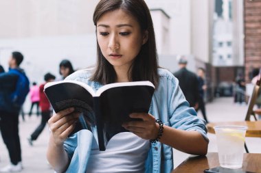 Düşünceli esmer kadın elinde kitapla sokaktaki ilginç roman senaryolarına odaklanmış. Çekici hippi kız, en çok satanlar listesinin en iyilerini inceleyerek şehir ortamında zaman harcıyor.