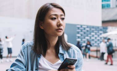 Japon yenilikçi blogcu elinde modern cep telefonu cihazıyla sosyal uygulama yaratmayı düşünüyor. Milenyum Asyalı bir kadın, Cafe Terrace 'da cep telefonu kullanıyor.