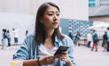 Japon yenilikçi blogcu elinde modern cep telefonu cihazıyla sosyal uygulama yaratmayı düşünüyor. Milenyum Asyalı bir kadın, Cafe Terrace 'da cep telefonu kullanıyor.
