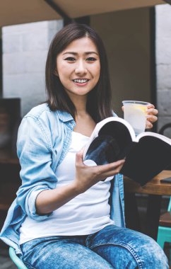 Kafeteryada edebiyat okuyan, elinde en sevdiği kitabı tutan genç ve pozitif bir kız öğrenci. Gülümseyen Çinli hippi kız, boş günlerini kafeterya terasında oturup romantik romanlar okuyarak geçiriyor.