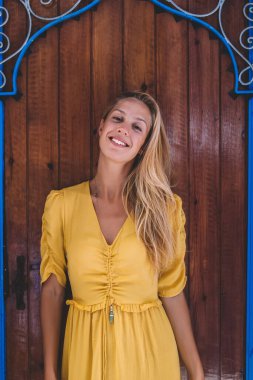 Yabancı ülkelerde gezen mutlu kadın gezginin yarım boy portresi. Yabancı bir şehirde gezen pozitif kadın gezgin. Tanıdık olmayan Chaouen caddesindeki bohem duvar binasının yanında duruyor.