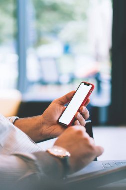 Kafkasyalı genç adamın elinde boş cep telefonu, bankacılık verilerinin doğrulanması, dizüstü bilgisayar ve cep telefonundan internet üzerinden alışveriş yapması ve web reklamları için ekran görüntüsü oluşturması.