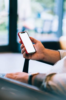 Kafkasyalı genç adamın elinde boş cep telefonu, bankacılık verilerinin doğrulanması, dizüstü bilgisayar ve cep telefonundan internet üzerinden alışveriş yapması ve web reklamları için ekran görüntüsü oluşturması.