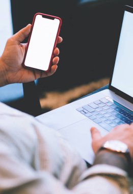 Kafkasyalı genç adamın elinde boş cep telefonu, bankacılık verilerinin doğrulanması, dizüstü bilgisayar ve cep telefonundan internet üzerinden alışveriş yapması ve web reklamları için ekran görüntüsü oluşturması