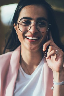 Mutlu İspanyol hipster kızı boş zamanlarında cep telefonuyla sanal iletişim kurmak için en iyi arkadaşına sesleniyor.