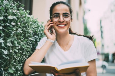 Mutlu kız öğrenci, üniversiteden yaz edebiyatı hakkında konuşmak için en iyi arkadaşına sesleniyor. Kadın okuyucu, en çok satanlar listesi hakkında duygusal olarak uluslararası internet kullanarak konuşuyor.