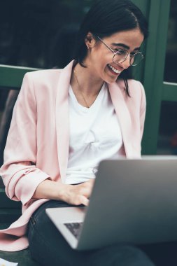 Mutlu genç duygusal girişimci heyecanlı ve mutlu hissediyor çalışma sürecini harika bir iş yapıyor gözlüklü başarılı bir hippi kız modern netbook ve kağıtlarla öğreniyor.