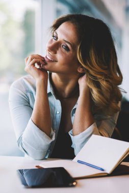 Mutlu başarılı kadın yazar en iyi satıcı için ders kitabı, pozitif hipster kız uzakta sevimli gülümseme ile kafeterya kahve bardağı ile otururken bakarak yazdı için iyi yapılmış bölüm zevk