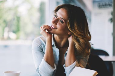 Mutlu başarılı kadın yazar en iyi satıcı için ders kitabı, pozitif hipster kız uzakta sevimli gülümseme ile kafeterya kahve bardağı ile otururken bakarak yazdı için iyi yapılmış bölüm zevk