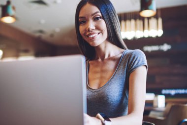 E öğrenme için modern dizüstü bilgisayar ile rahat kafeterya dinlenmek mutlu kadın öğrenci portresi, uygulama yoluyla arkadaşlarınızla iletişim kurmak için Netbook kullanarak başarılı hipster kız