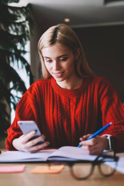 Pozitif kadın Blogger Web sitesinde sonraki içerik yayını için makale yazmak için ilginç bilgiler arıyor, mutlu hipster kız planlama önümüzdeki hafta App üzerinden arkadaşlarınızla mesajlaşma sırasında