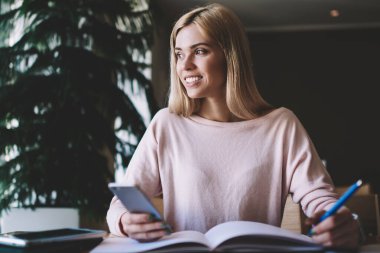 Sınıf içinde üniversite başlangıç projesi üzerinde çalışma break uzak seyir mutlu kadın öğrenci, olumlu hipster kız eğitim molası zevk kapalı öğrenme için Smartphone Gadget kullanarak