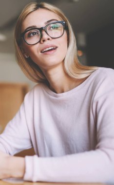 Elele akıllı telefon gadget tutarak ve wifi bağlantısı beklerken vizyon düzeltme için gözlük düşünceli pensive kız öğrenci, boş ekran masada kalan bilgisayar