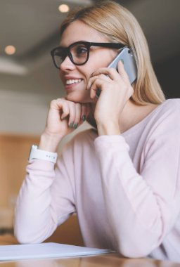 İçerik veya Web sitesi için boş ekran ile modern netbook üzerinde mesafe iş break akıllı telefon uygulaması ile arkadaş ile tebliğ göz düzeltmesi için gözlükler içinde mutlu kadın uzak işçi