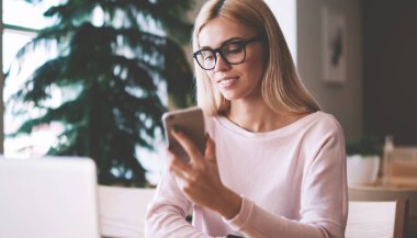 Gözler ekran akıllı telefon dokunmatik ekranı kontrol sağlamak için gözlükler başarılı hipster kız, arkadaşlar ile iletişim için modern mobil ve dizüstü cihazlar kullanarak giyinmiş pozitif kadın Casual