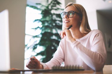 Laptop cihazı ile masada otururken yeni çocuk kitabı için fikirler hakkında düşünce pozitif dalgın kadın yazar, optik gözlük düşünceli hipster kız üniversite için kompozisyon üzerinde durulıyor