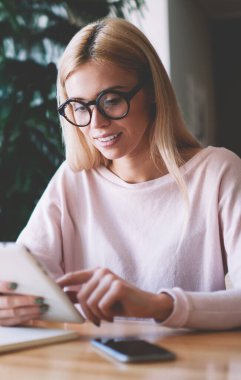 Burs hakkında iyi haber ile üniversite yönetiminden mutlu kadın kolej öğrencisi okuma e-posta, yeni optik gözlük pozitif hipster kız dijital tablet üzerinde internet tarama