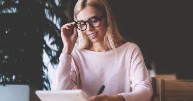 Kampüste üniversite öğrencisi hayatı hakkında olumlu haber okuma gözlükler genç müreffeh hipster kız, başarılı kadın Blogger mutlu sosyal ağda takipçisi iyi e-posta okumak için